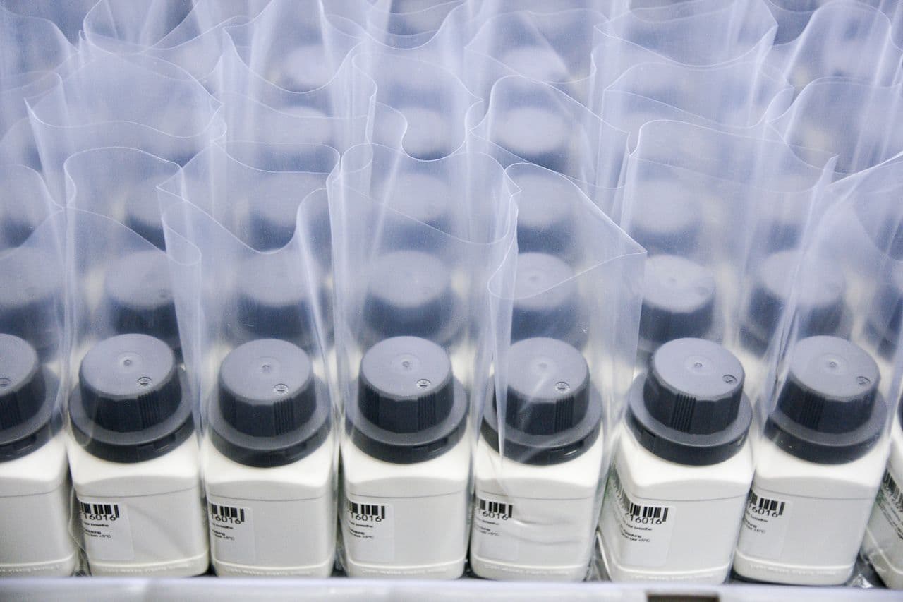 Rows of filled and labelled product bottles in protective film, ready for dispatch.