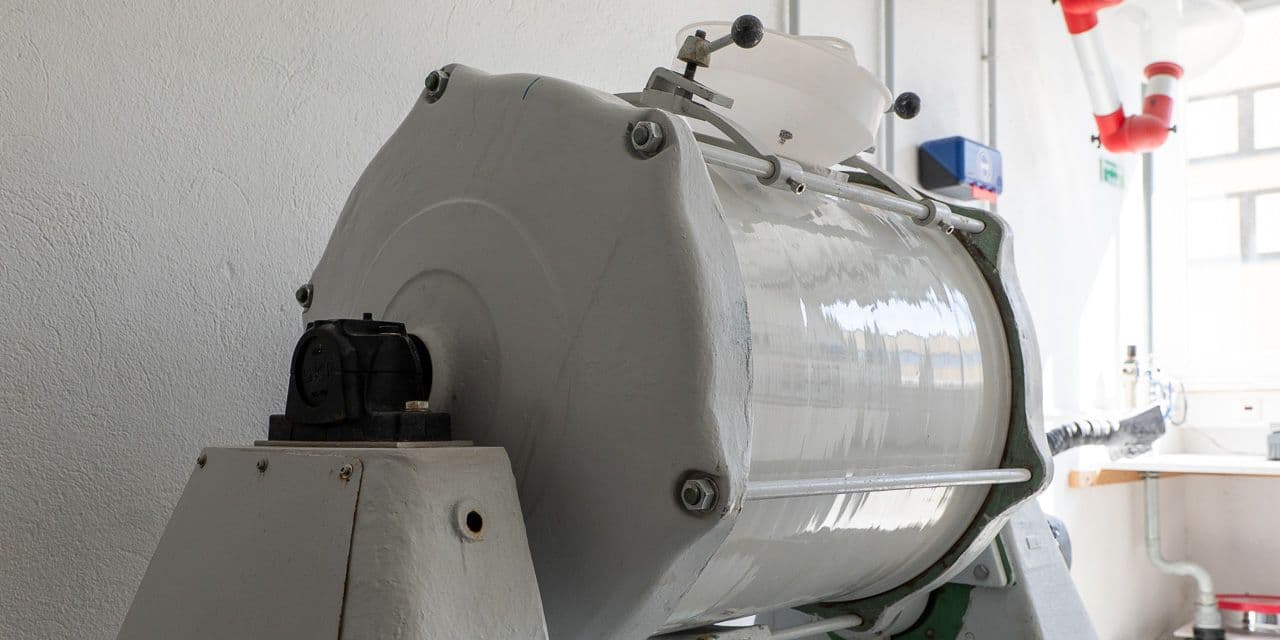 Ball mill with its drum mounted, used for milling phosphor powder.