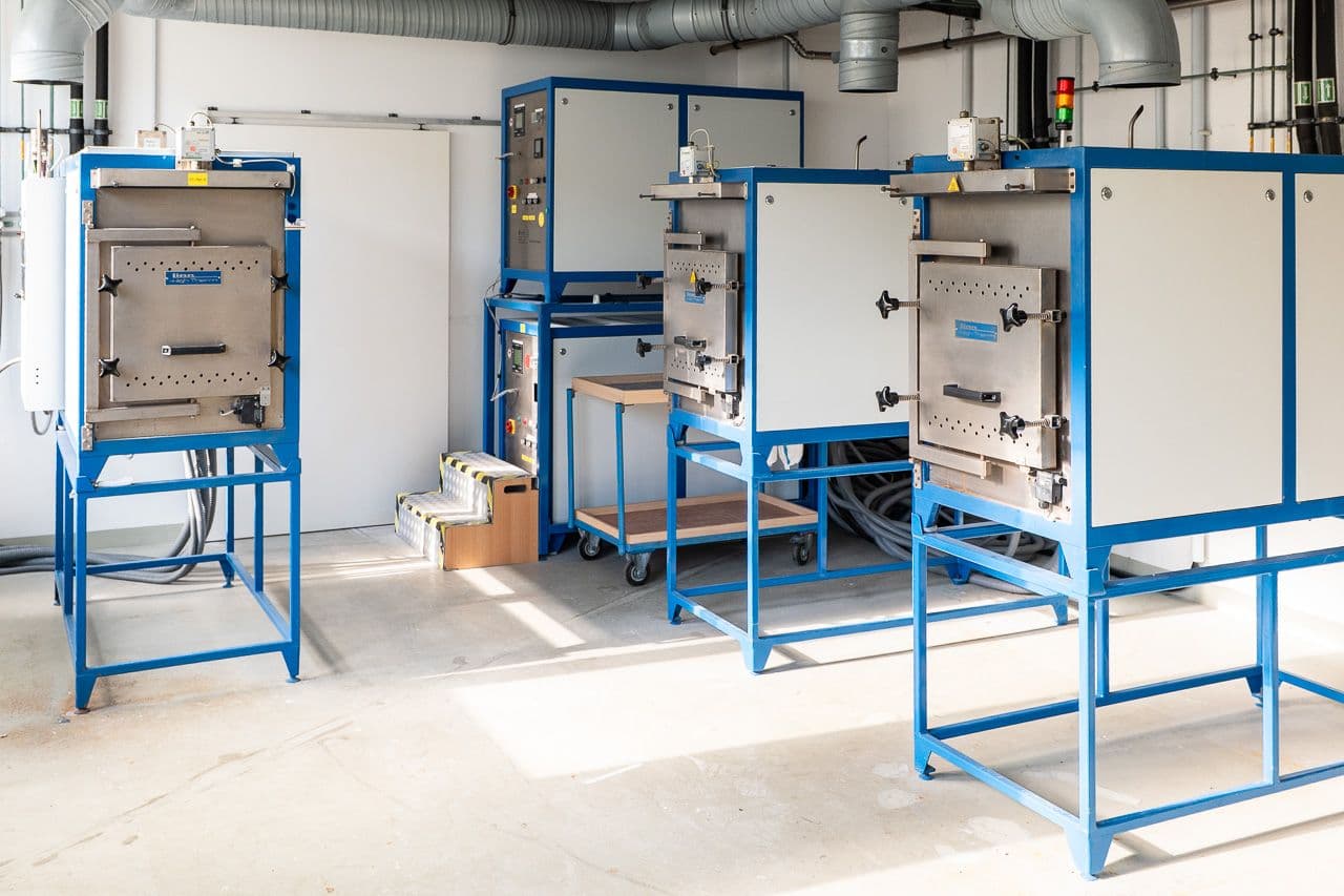 Four high-temperature chamber furnaces with open doors in the Litec-LLL synthesis area.